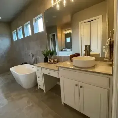 A bathroom with a tub , sink and mirror.