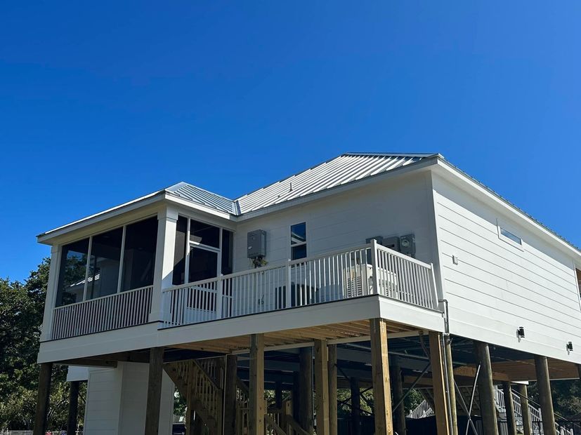 The house is being built on stilts and has a large deck.