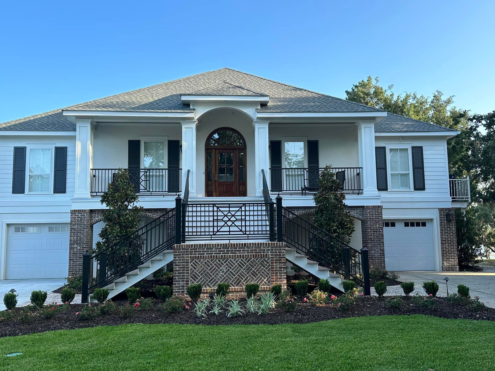 A large white house with black shutters and stairs