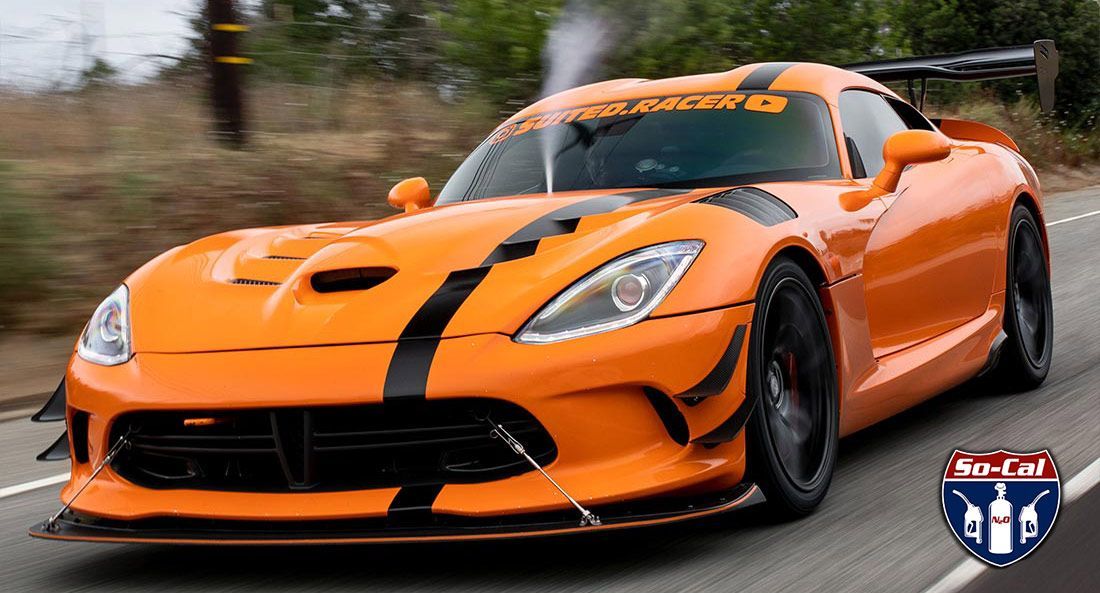 Orange Dodge Viper race car, black stripes, driving on a road.