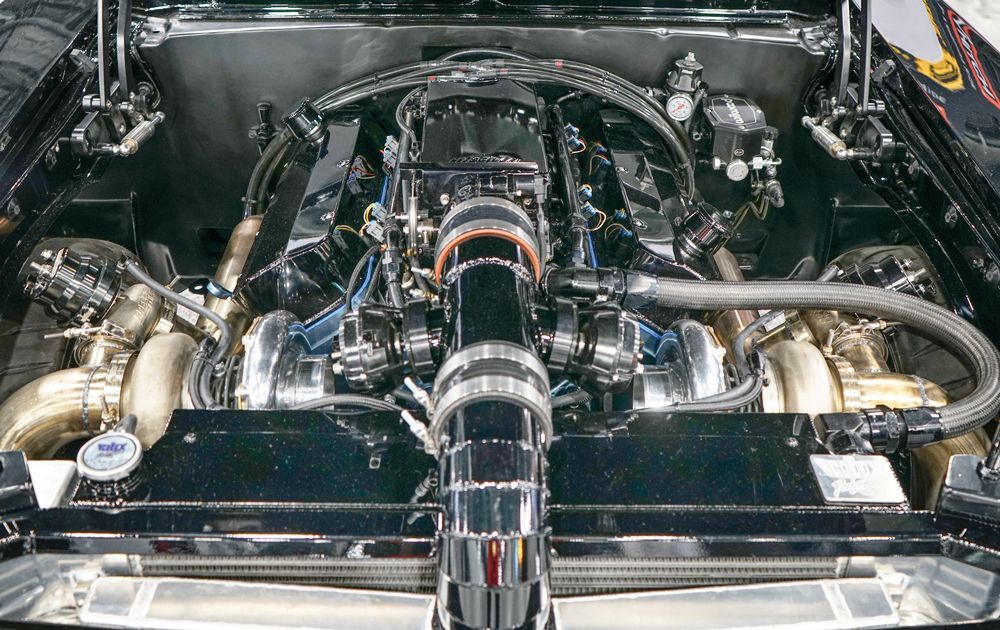 Shiny car engine with dual turbos and polished metal components.