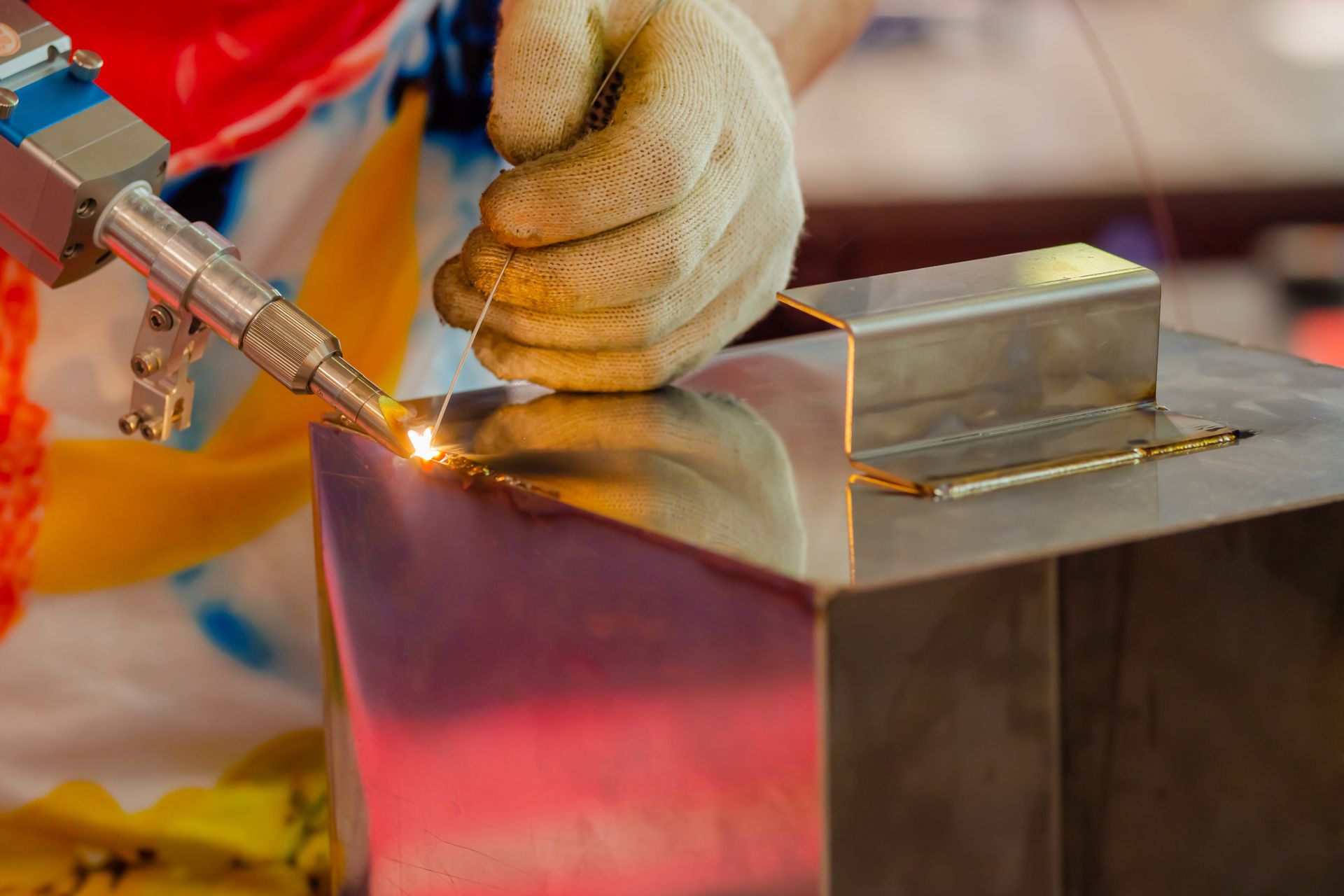 A person is welding a piece of metal with a machine.