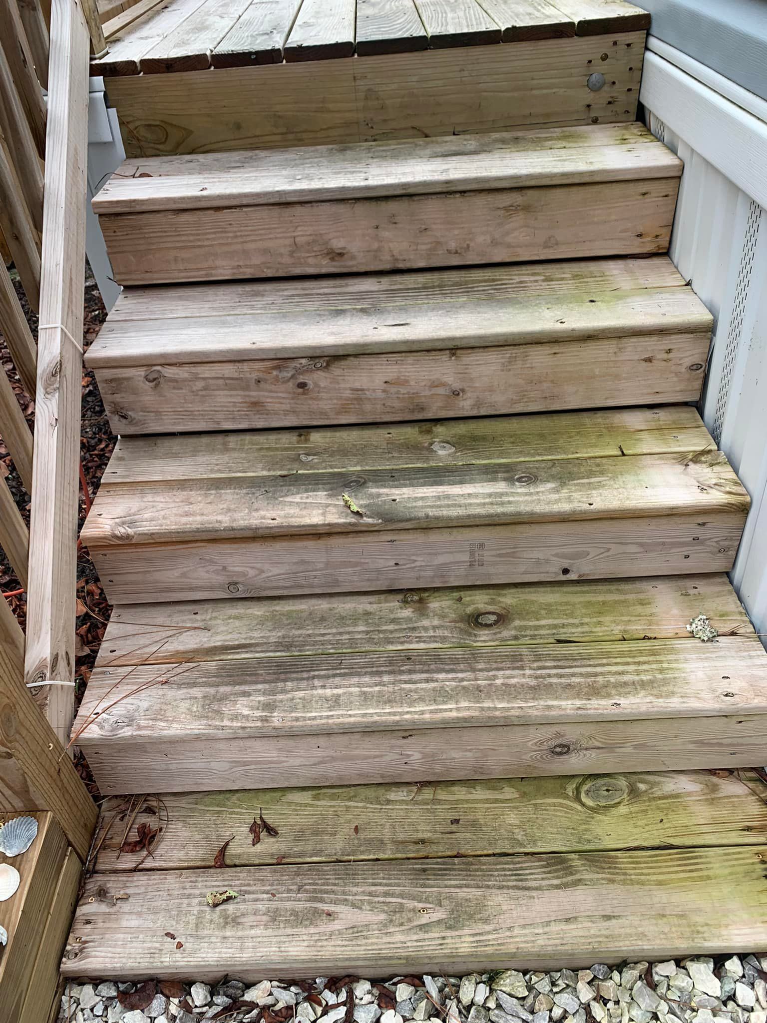 Weathered wooden outdoor steps with moss and dirt buildup on the treads