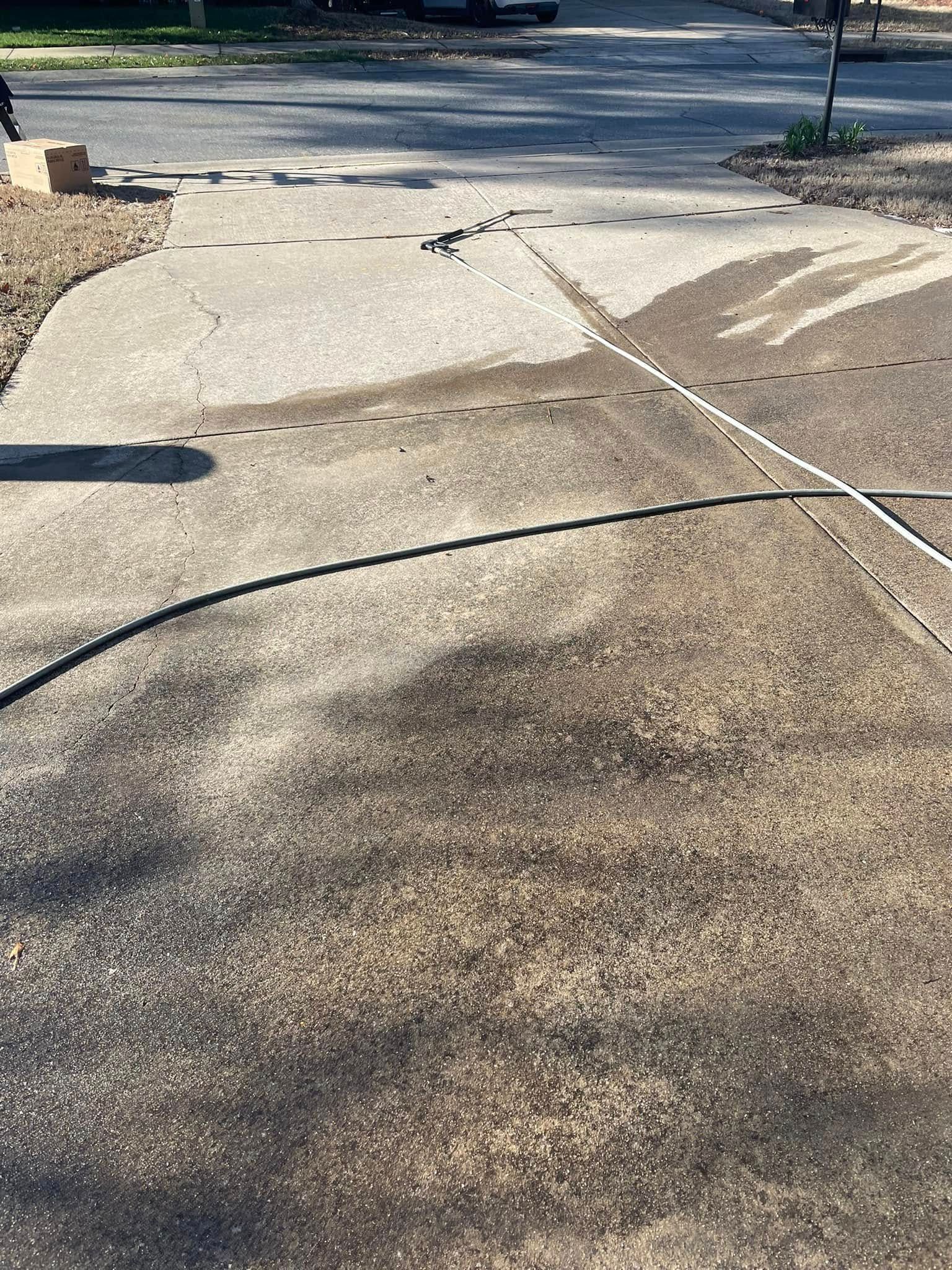 Cracked concrete sidewalk and curb ramp with a cable or hose stretched across the path