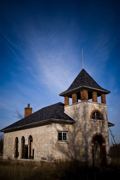 Old, weathered building with a tower under a bright blue sky. Old, weathered building with a tower under a bright blue sky.