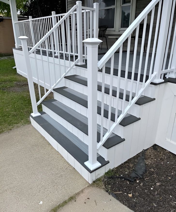 White railing and steps leading up to a porch with gray treads.