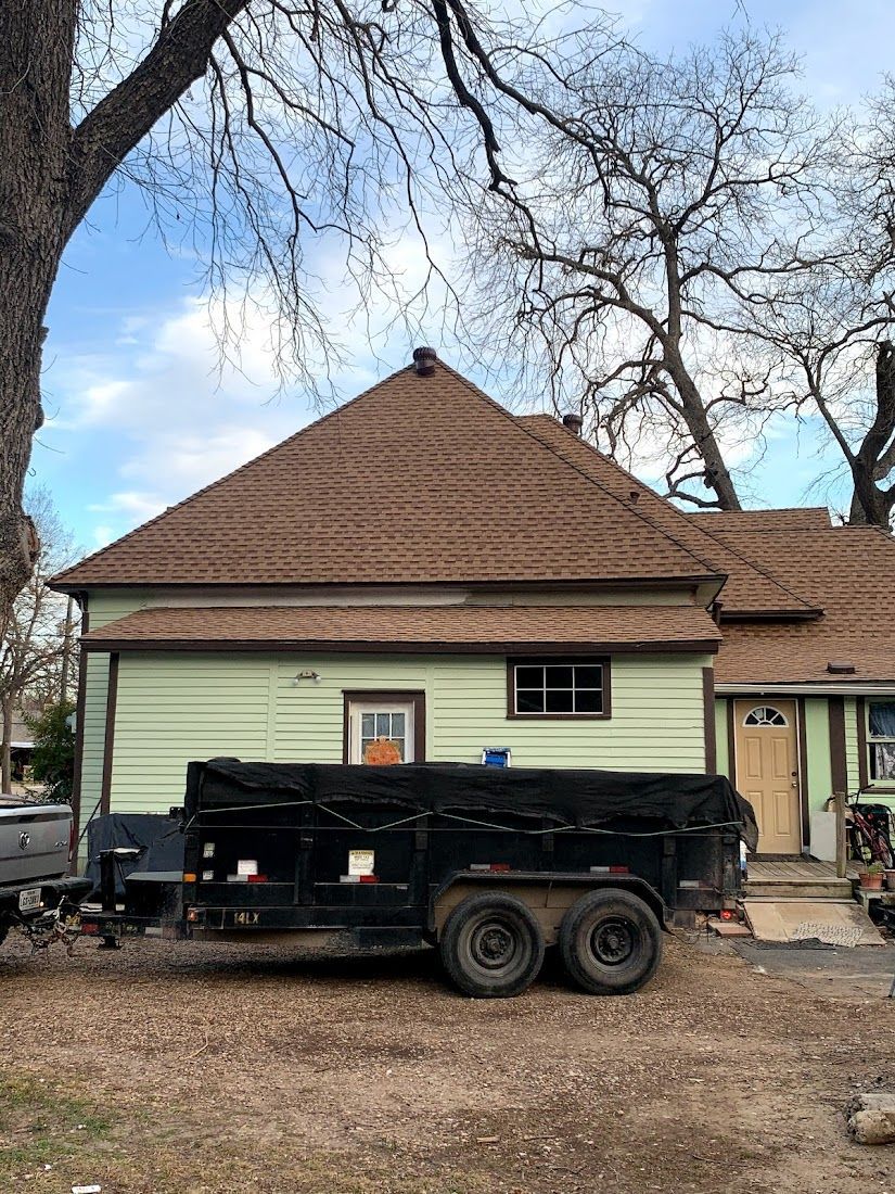 A dumpster is parked in front of a house.