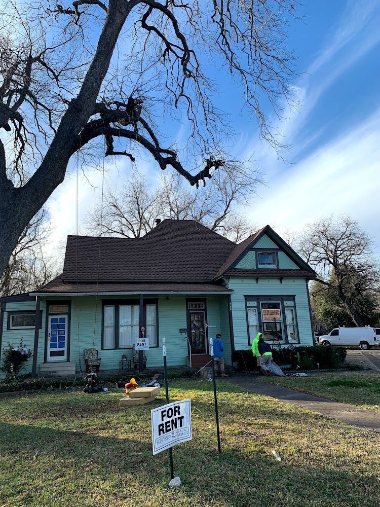 A green house with a for rent sign in front of it.
