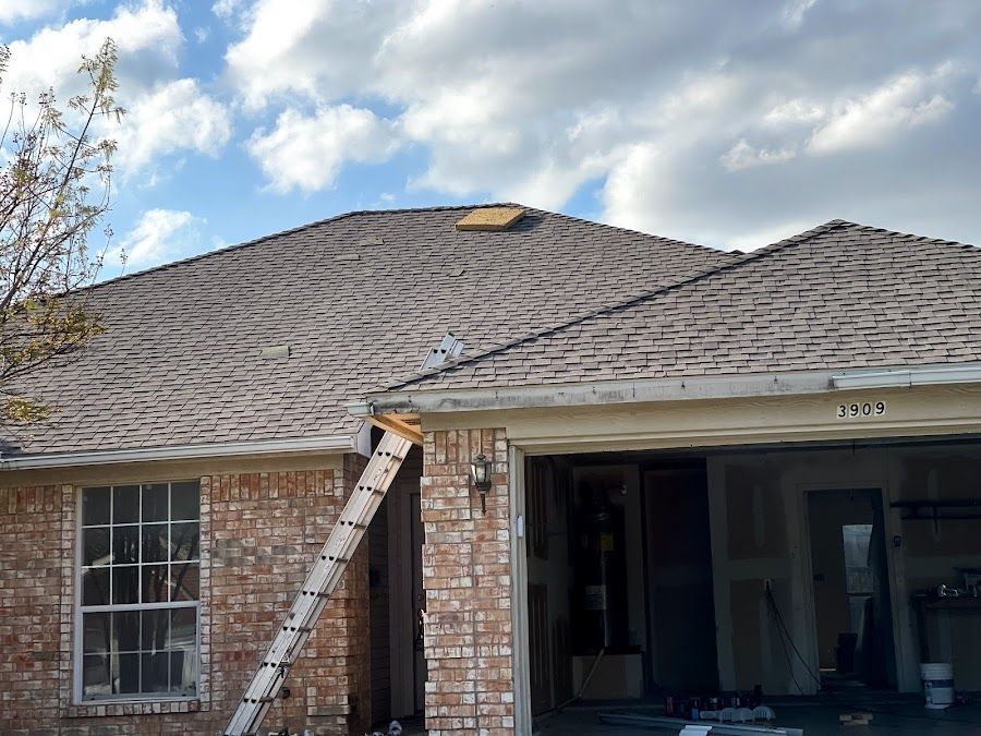 A ladder is leaning against the side of a brick house.