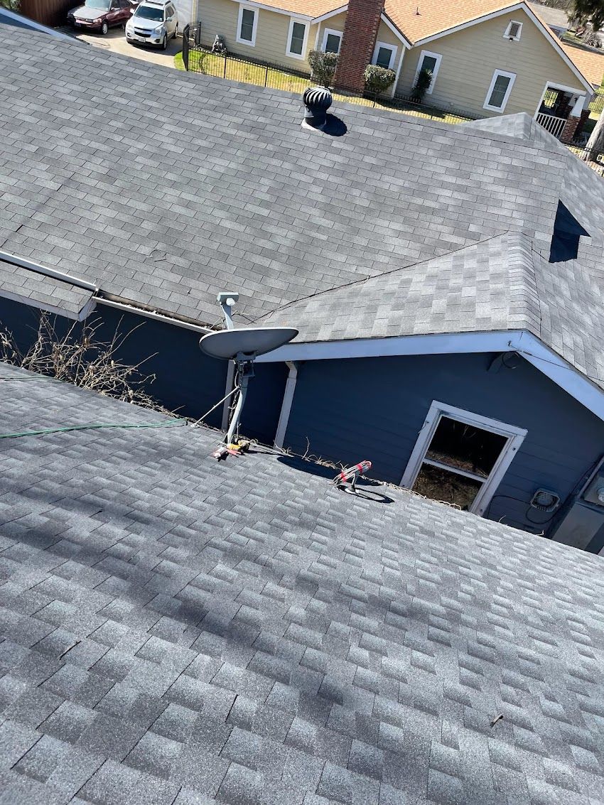 A person is standing on the roof of a house.