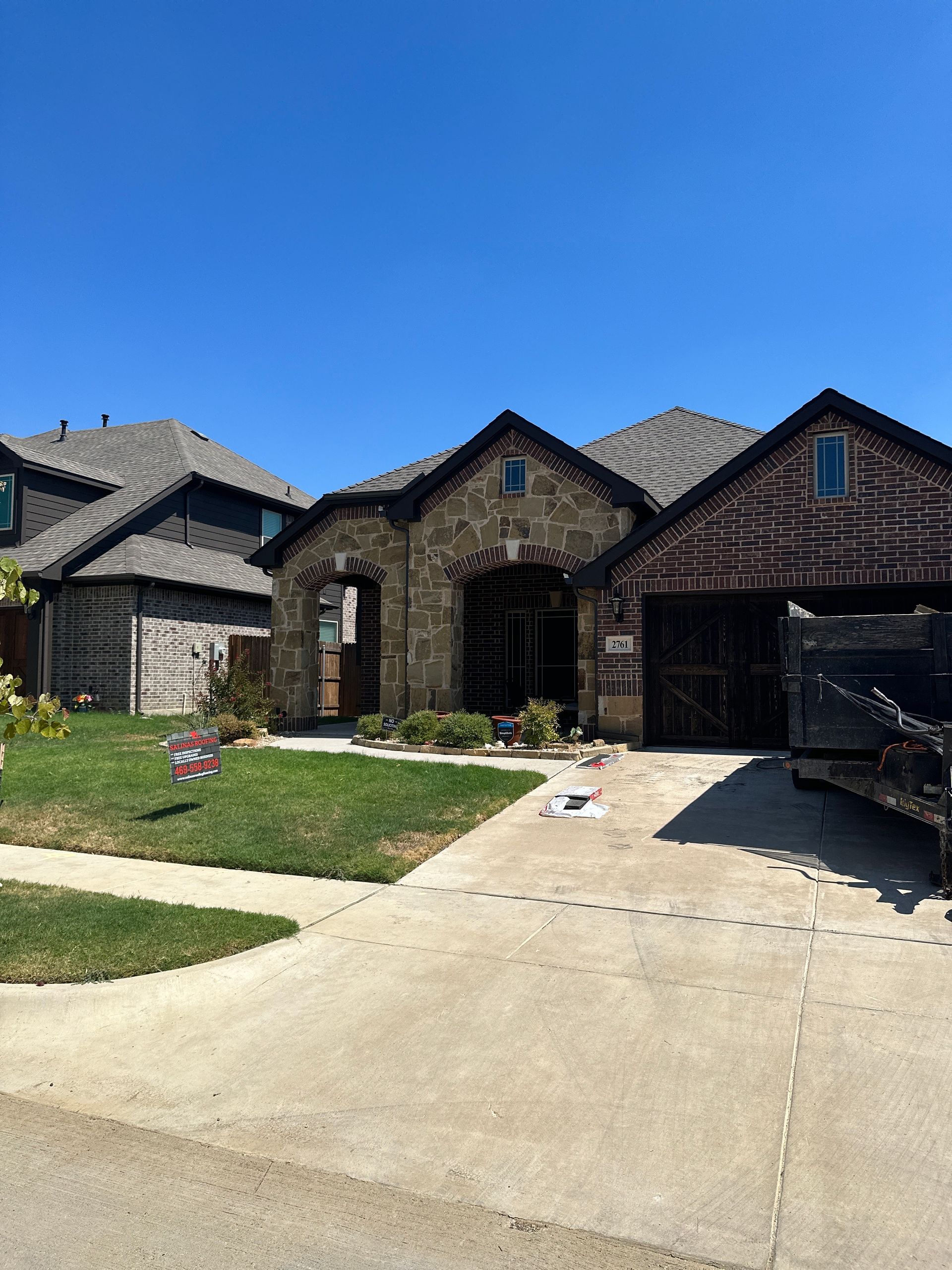 A large brick house with a dumpster in front of it.