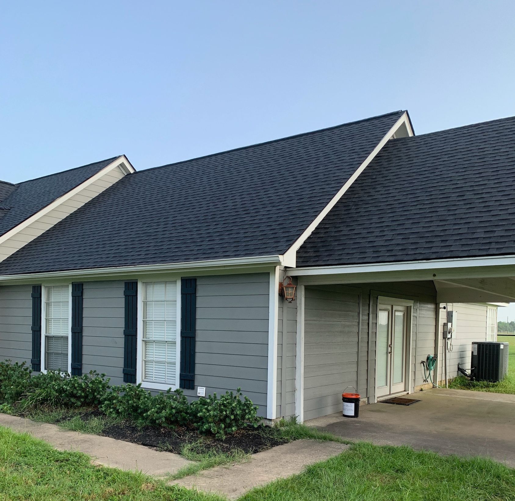 A gray house with a black roof and black shutters