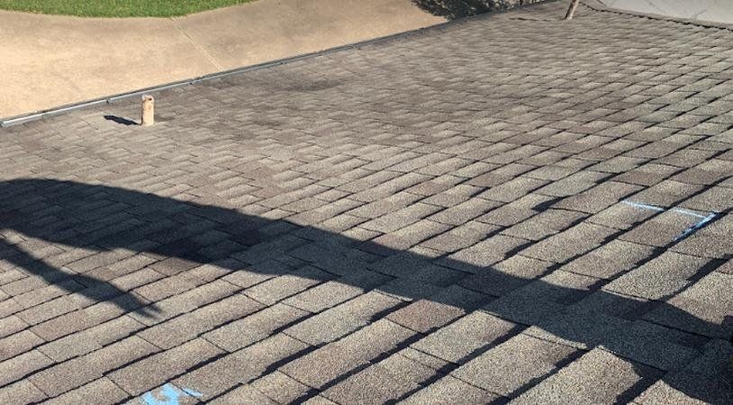 A close up of a roof with a shadow on it.