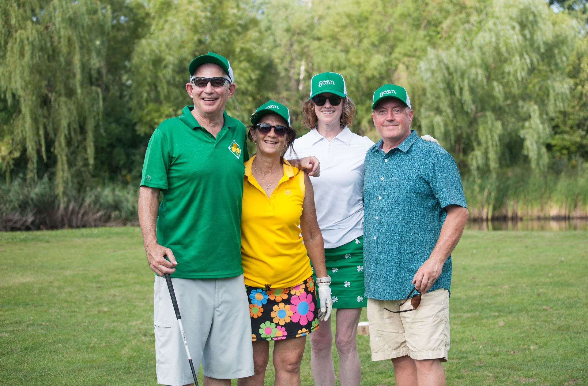 A group of people are posing for a picture on a golf course.