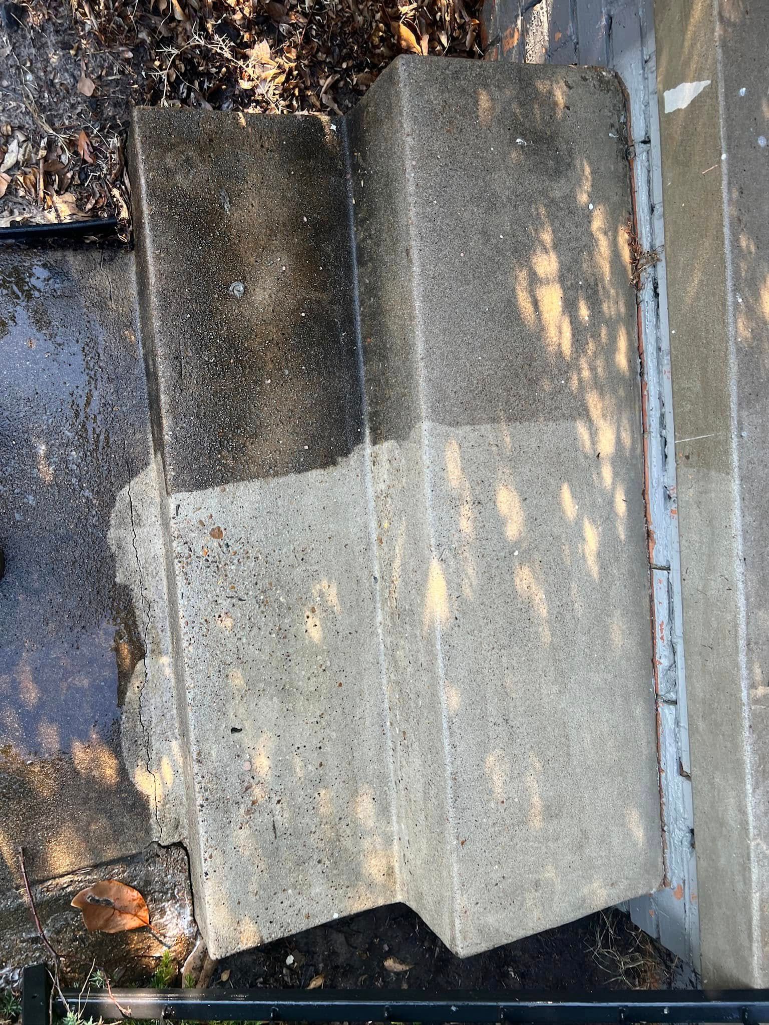 Concrete steps partially cleaned with pressure washer. One side is dark, the other is light.