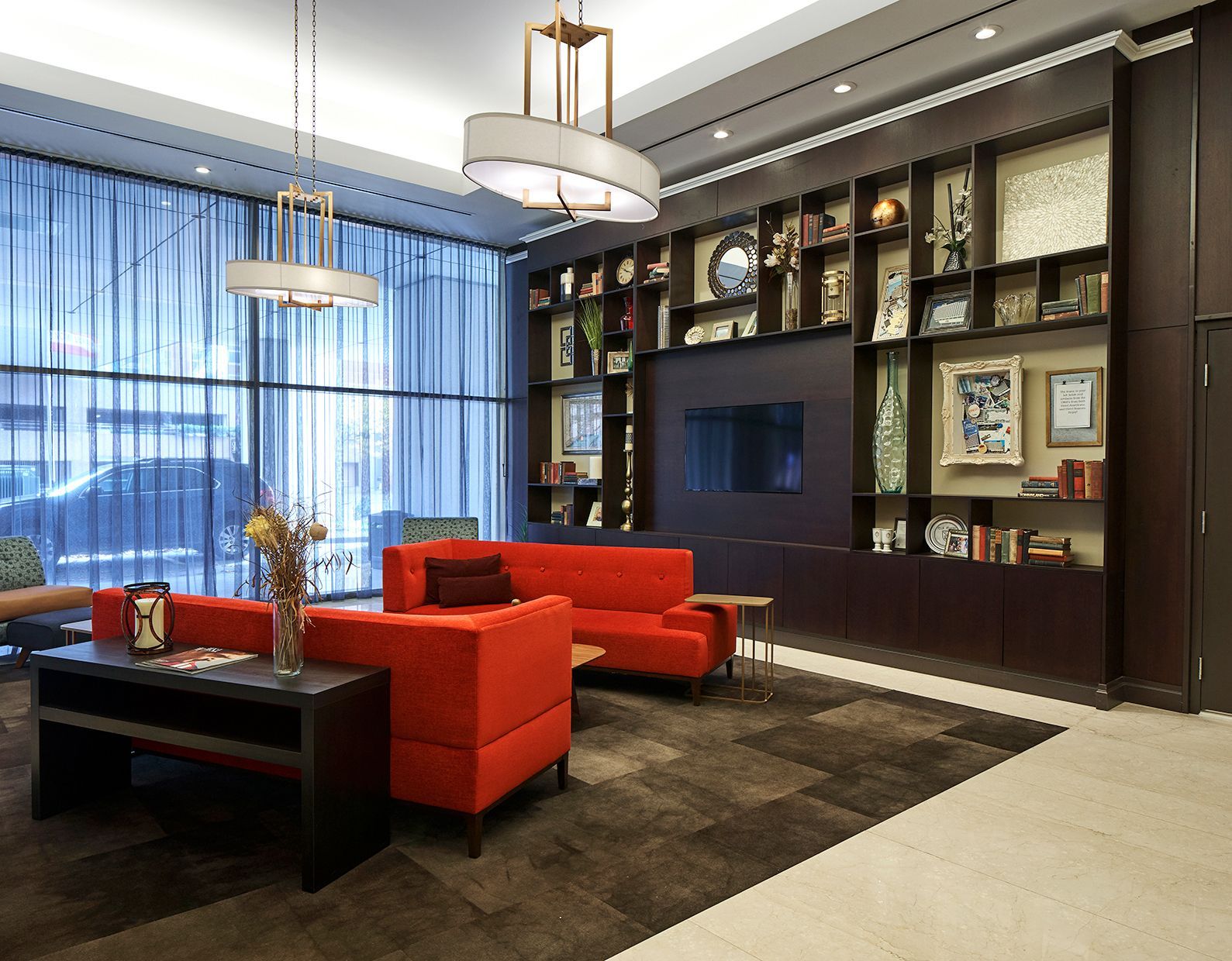 A living room with a red couch and chairs