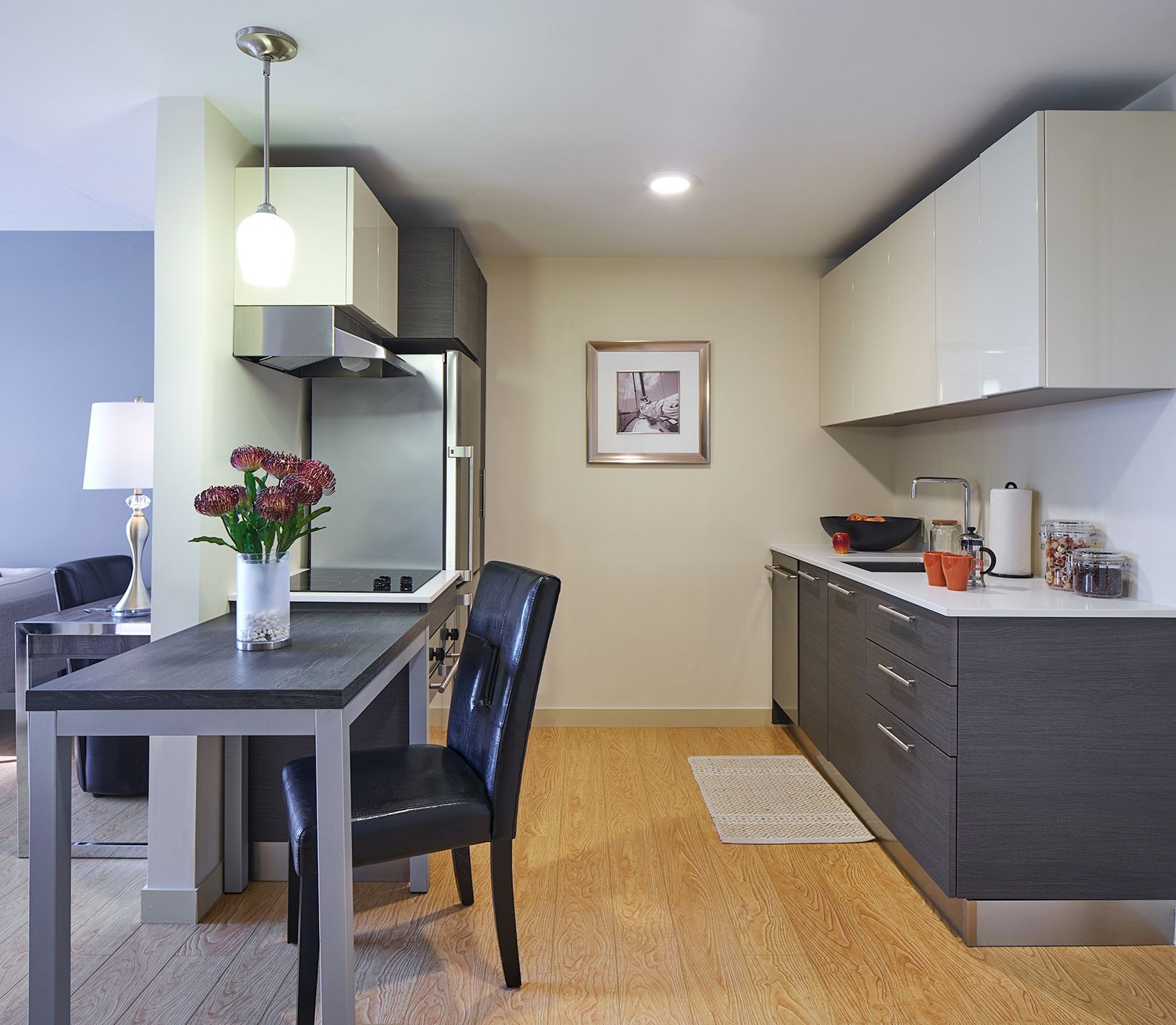 A kitchen with a table and chairs and a vase of flowers
