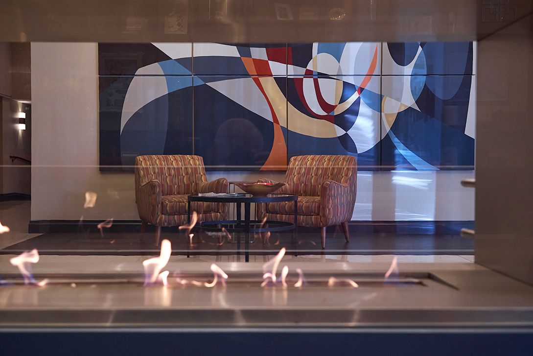 A living room with a fireplace and a painting on the wall