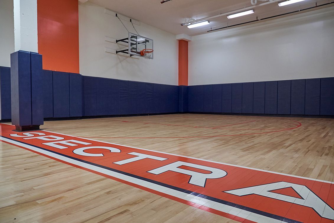 A basketball court with the word spectra painted on the floor