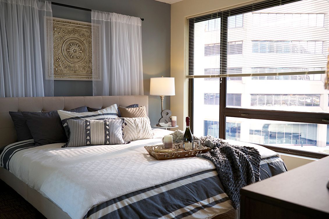 A bedroom with a large bed and a large window.