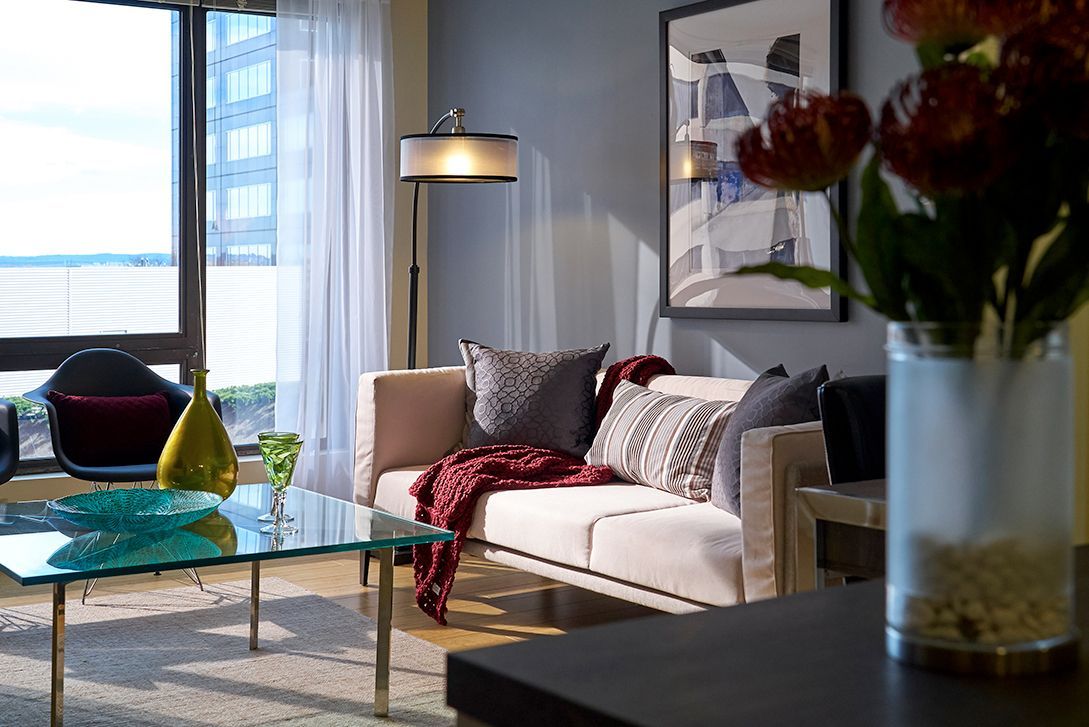 A living room with a couch and a vase of flowers