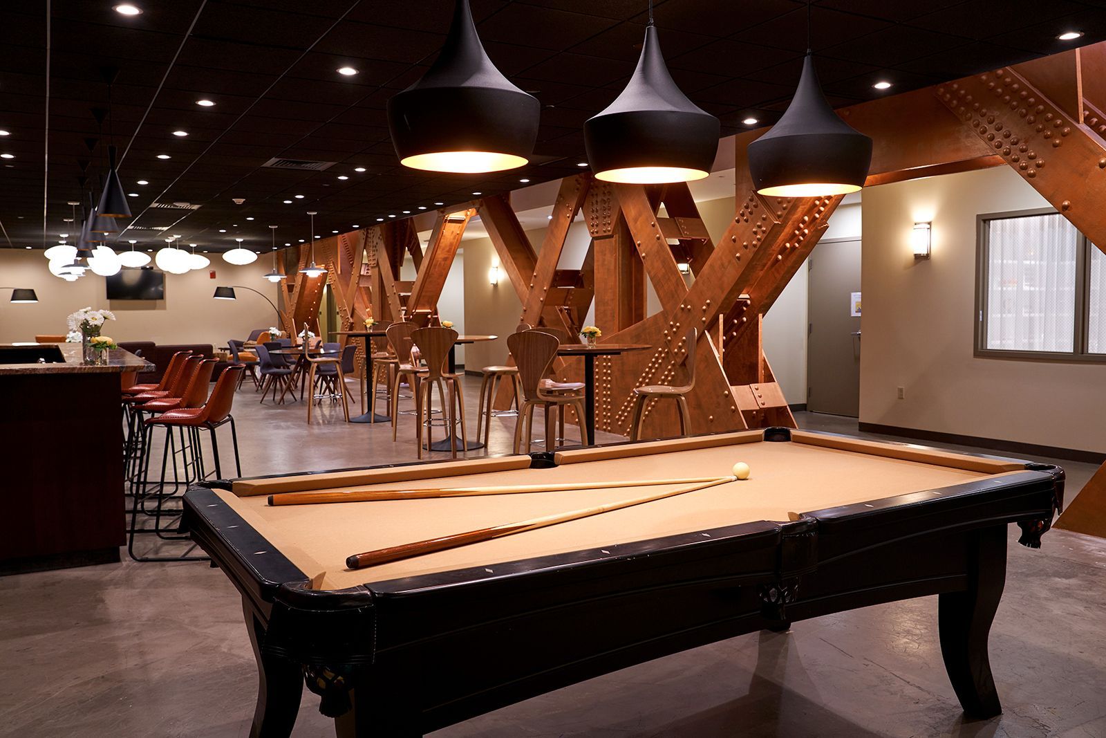 A pool table in a room with tables and chairs
