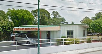 A van is parked in front of a vanguard auto tinting store