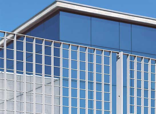 Un edificio azul con una valla blanca delante.