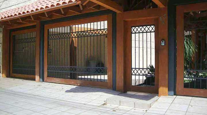 Una casa con una valla de madera y una puerta de metal.