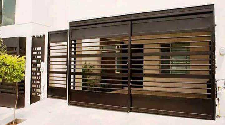 Una casa blanca con una puerta marrón y un árbol delante de ella.