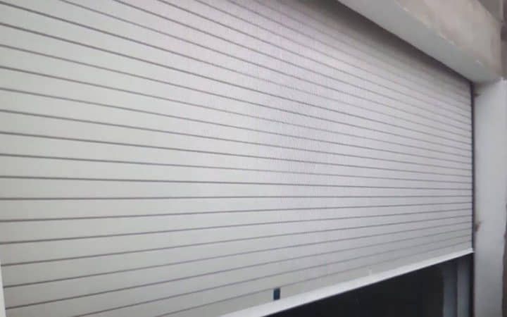 Un primer plano de una persiana blanca en una puerta de garaje.