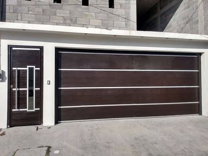 Una casa con una puerta de garaje marrón y una puerta blanca.