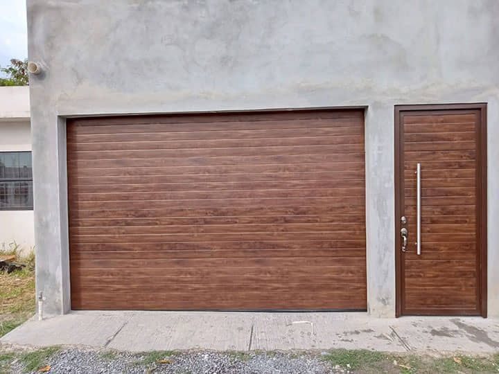 Una puerta de garaje y una puerta están en el costado de un edificio.