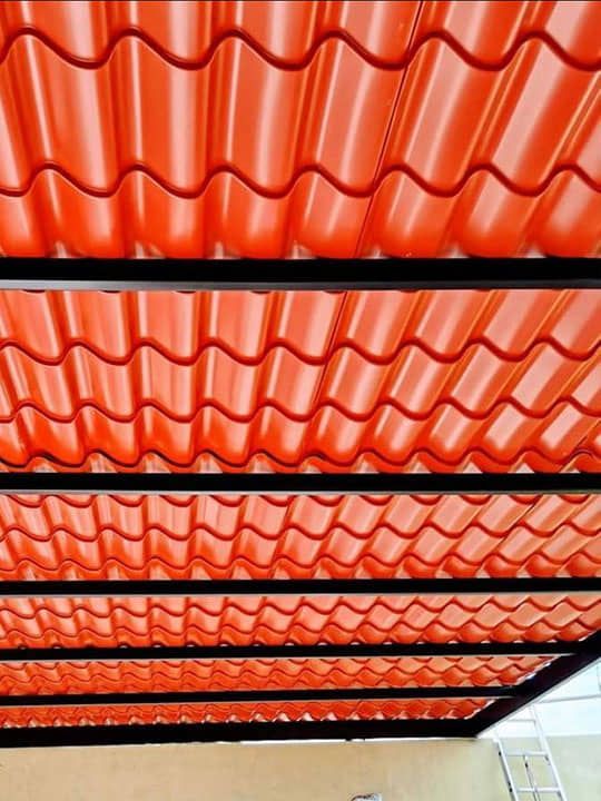 Un primer plano de un techo de tejas rojas con marco de metal.