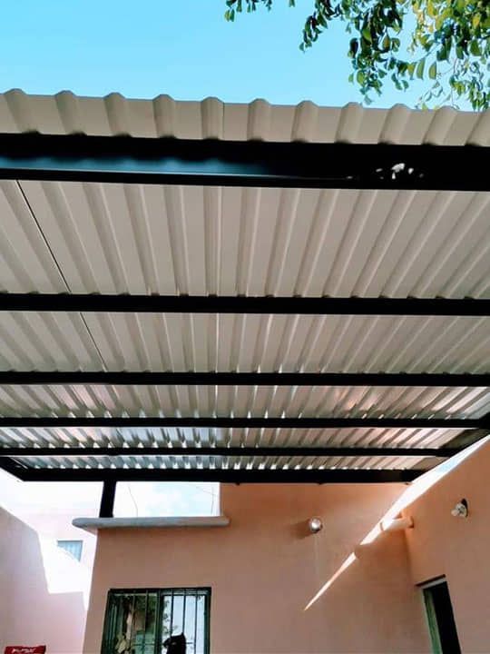 Un edificio rosa con techo blanco y marco negro.