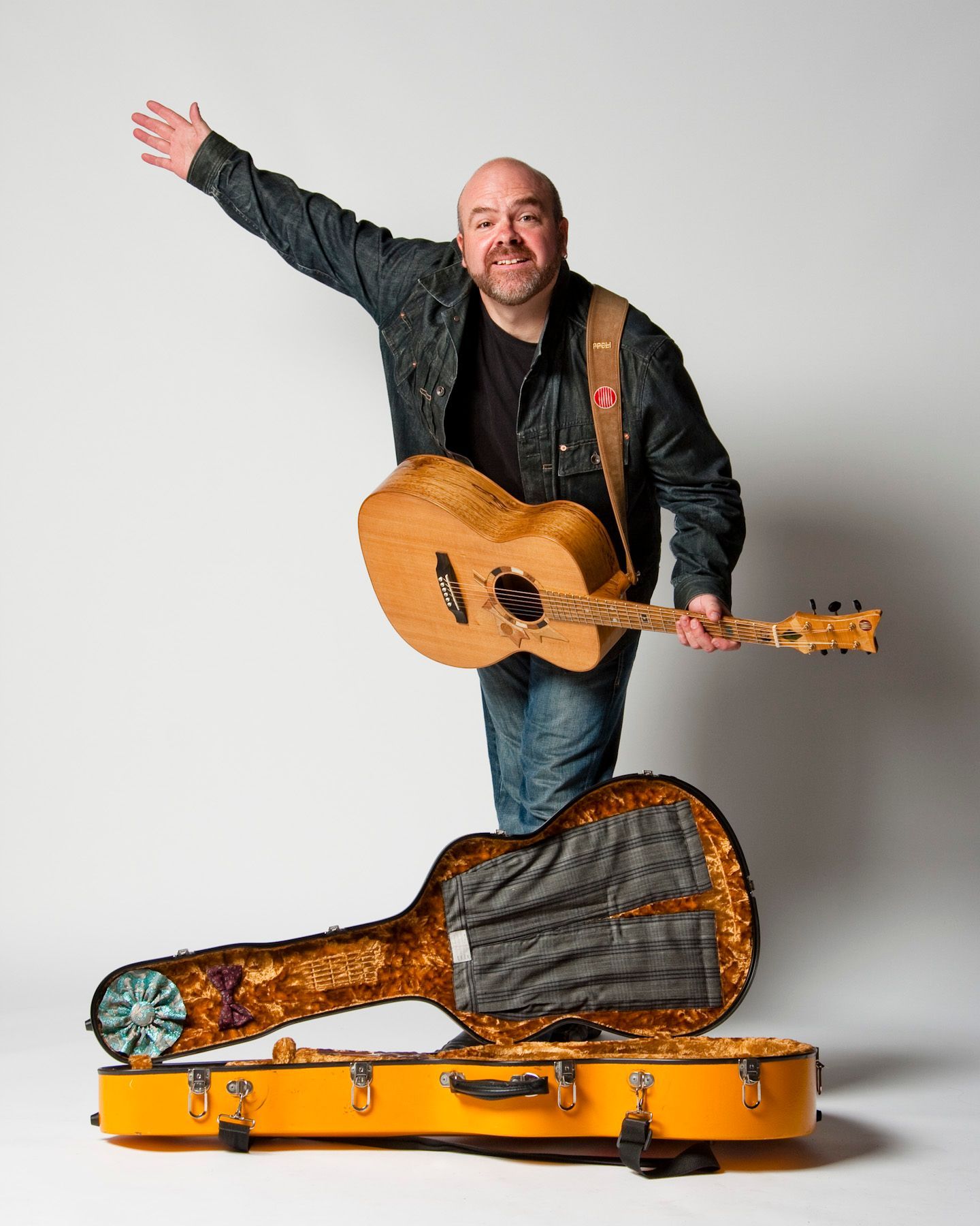 Portrait of songwriter David Leask taking a flourishing bow while holding  Voyageur - the guitar case open on the floor in front of him. Taken at Harbourfront Centre in Toronto on September 8, 2009