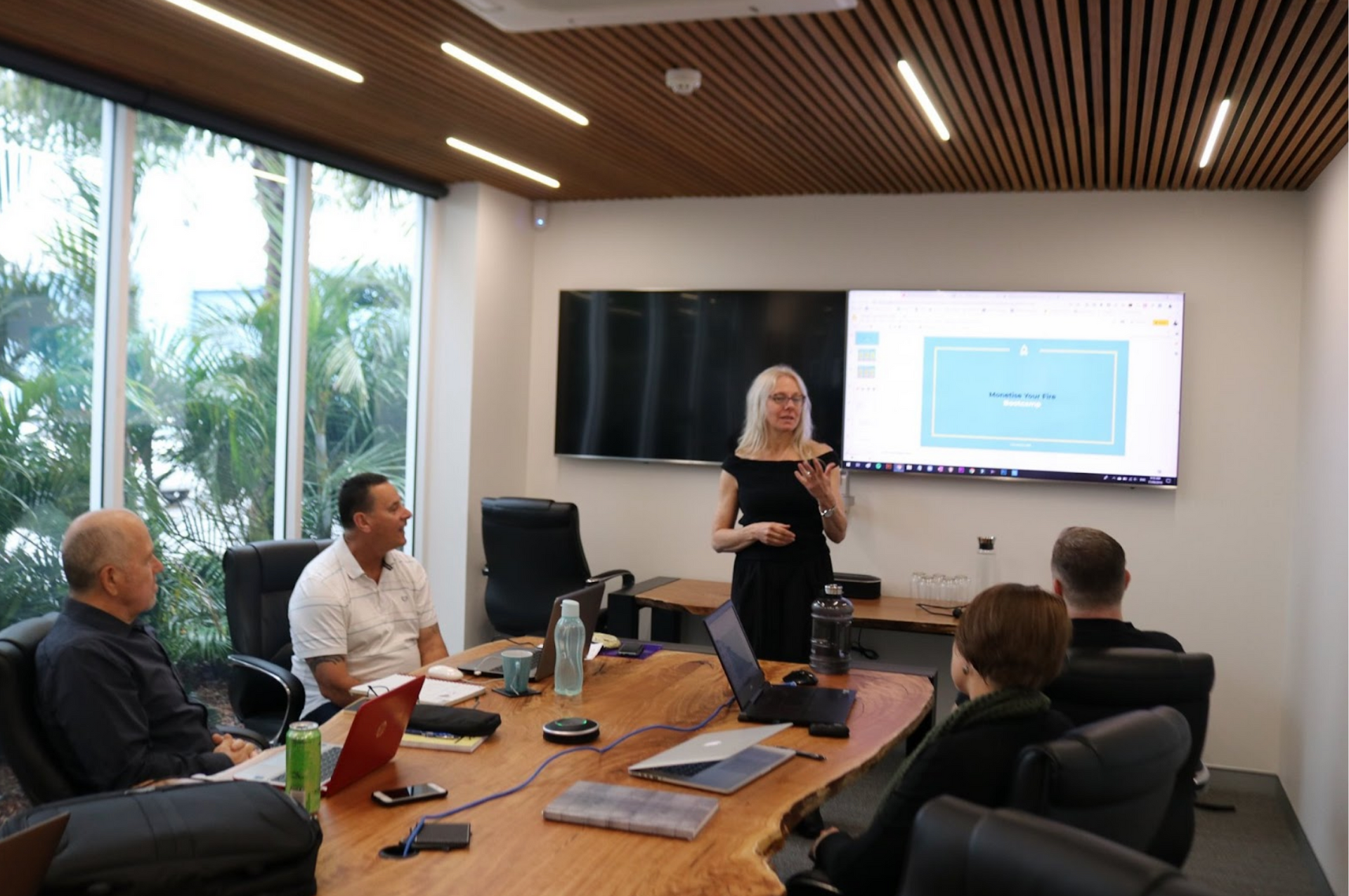 Toni Knight is giving a presentation to a group of people in a conference room.