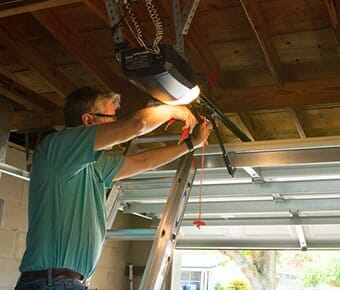 Garage repair service technician man working — Residential Garage Doors in Fredericksburg, VA
