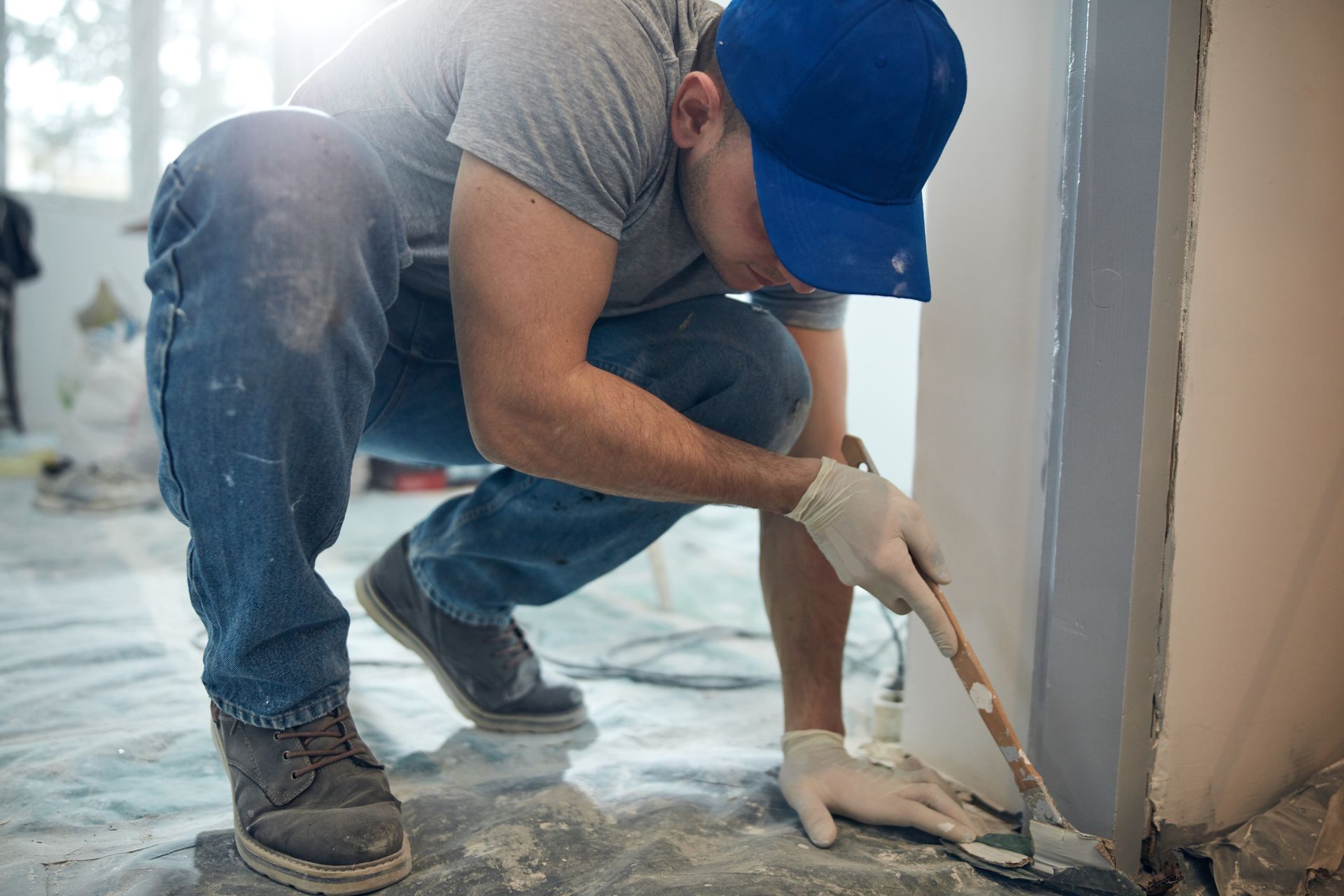 Young man repairing foundation cracks during a budget home restoration project.