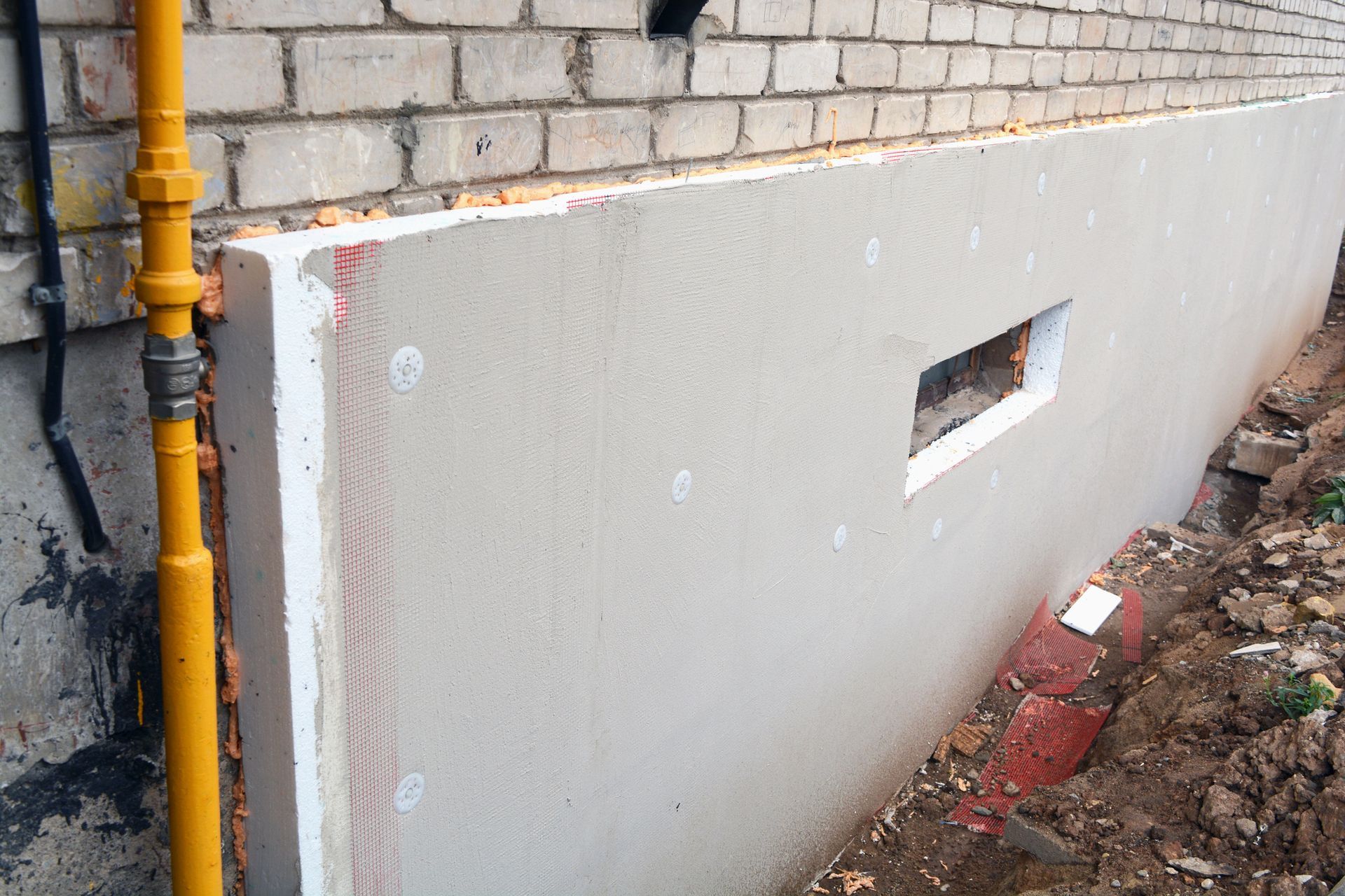 Old brick flat foundation has a white polystyrene on top to insulate the wall.