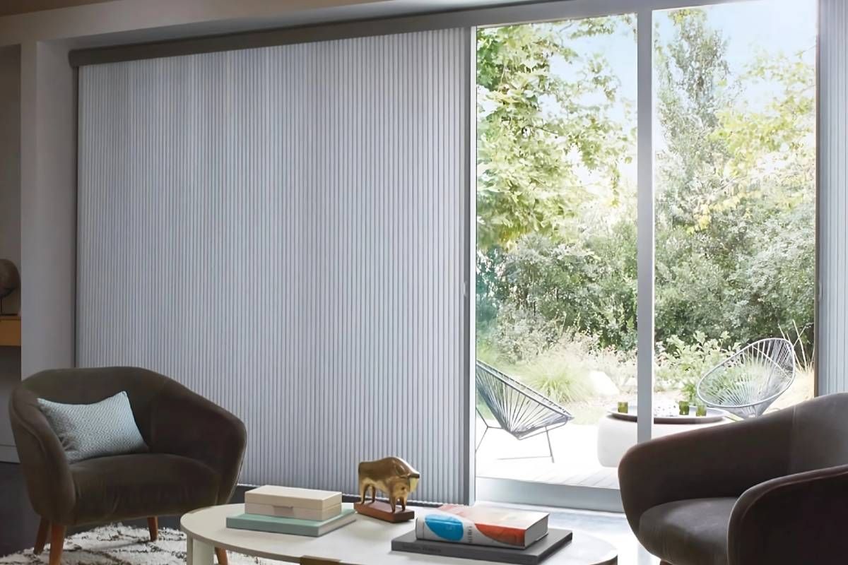 Hunter Douglas Duette® Cellular Shades for sliding glass doors in a living room overlooking a backyard at Harmony Blinds & Shutters near San Diego, CA