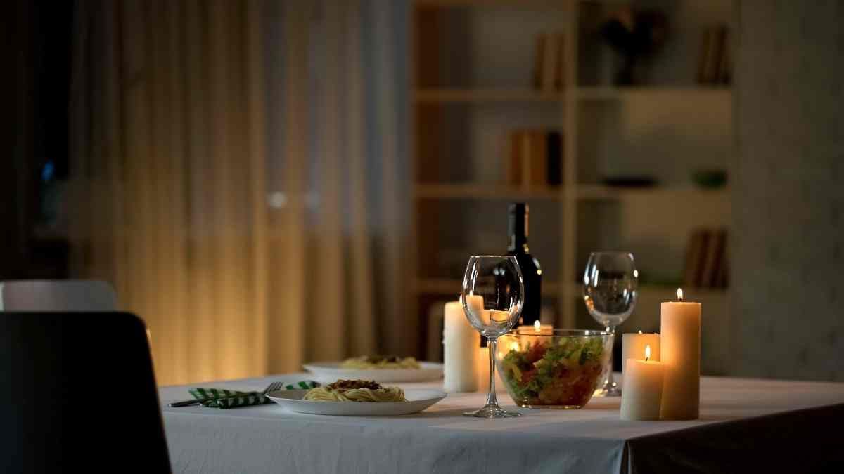 Dining room window treatments in the background of an at-home dinner featuring candles, dinner, and glasses at Harmony Blinds & Shutters near San Diego, CA