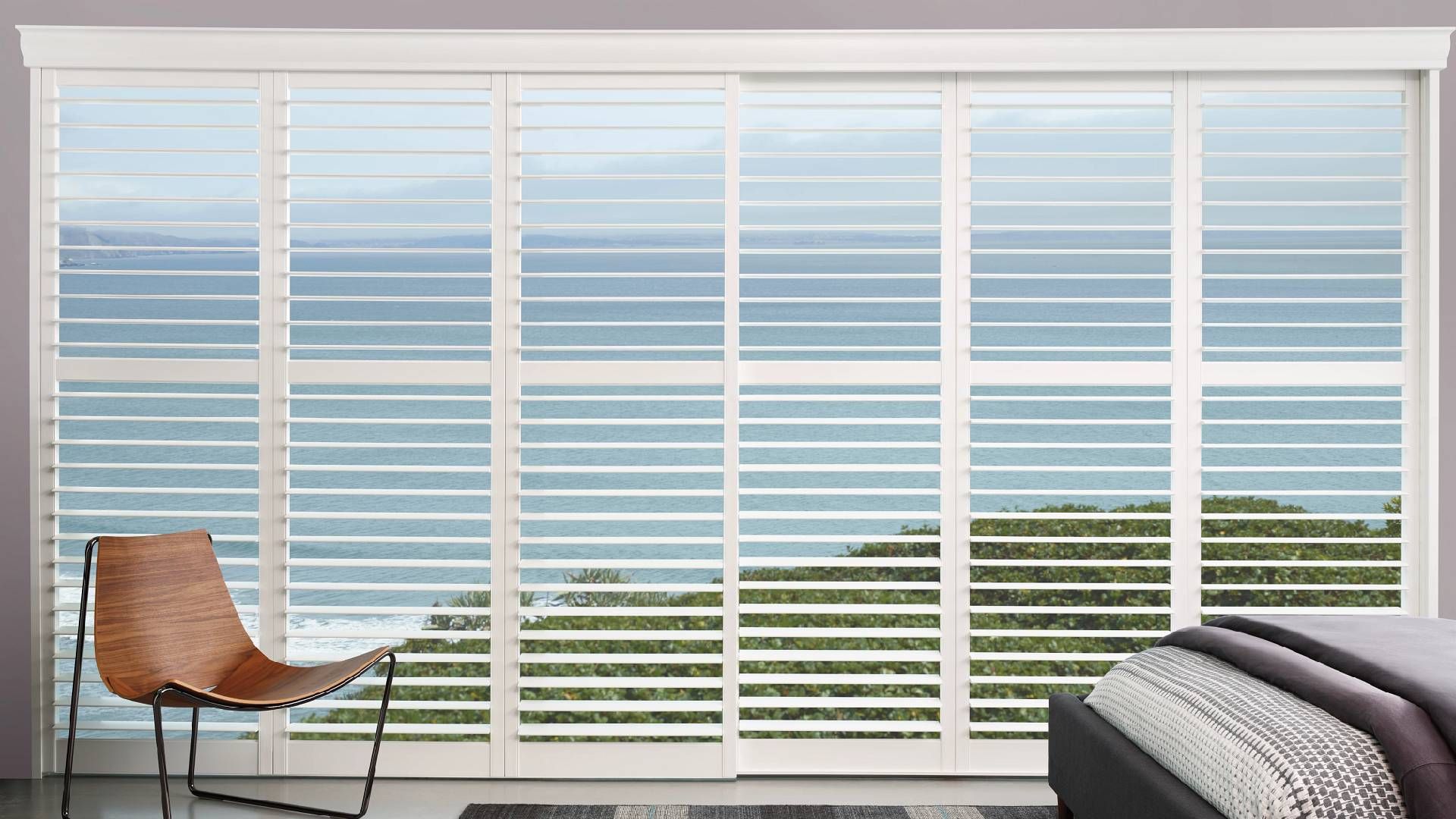 Hunter Douglas Palm Beach™ Polysatin™ Shutters decorating a coastal home bedroom at Harmony Blinds &