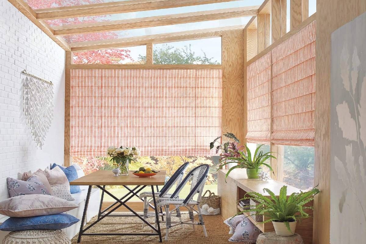 Sunroom with bright windows decorated with Hunter Douglas Drapery at Harmony Blinds and Shutters nea