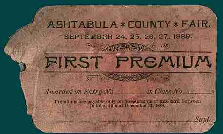 A faded tan paper card awarding a First Premium at the 1889 Ashtabula County Fair, with blank lines for entry details.