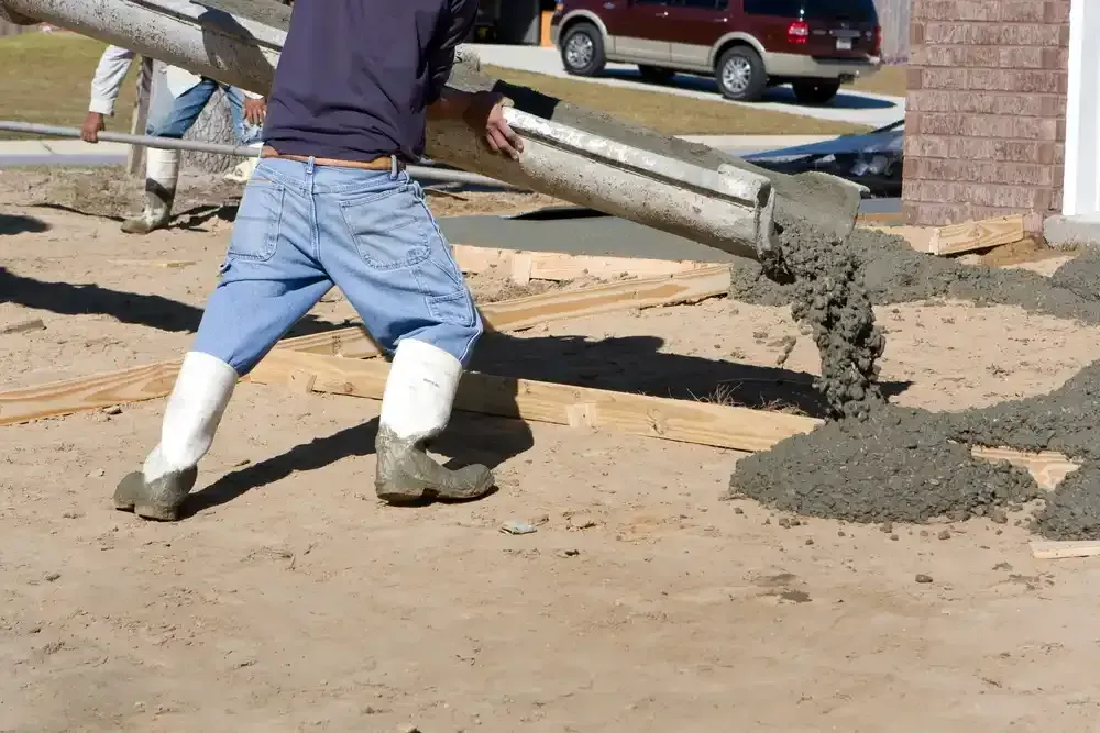A man is pouring concrete from a concrete pump