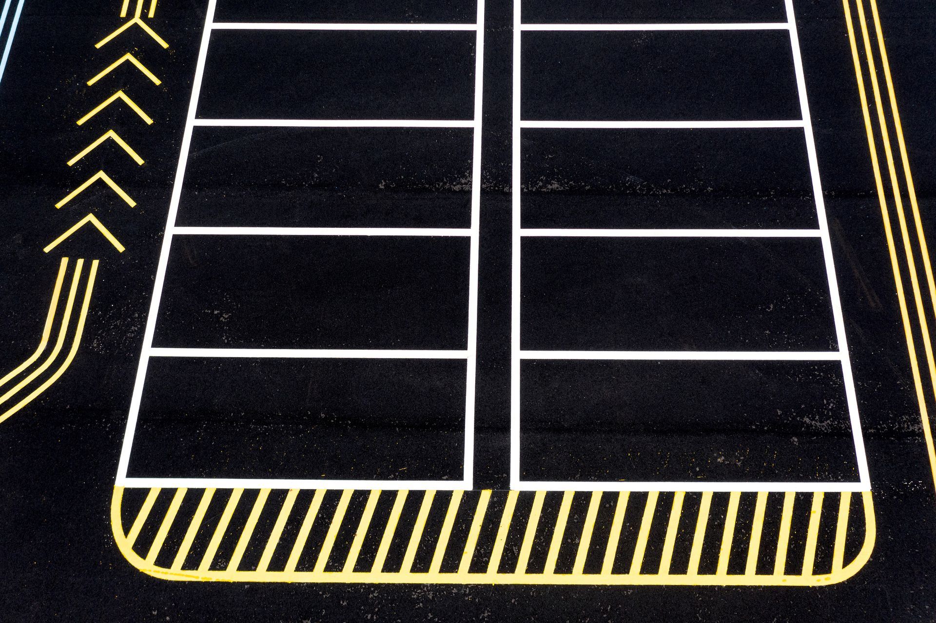 A parking lot with white lines and yellow stripes