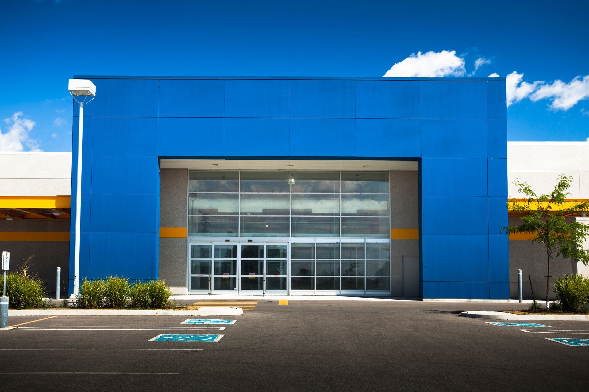 A blue building with a parking lot in front of it
