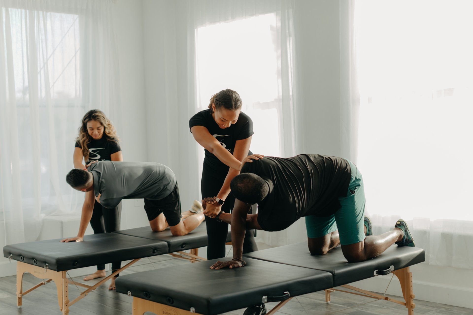 Male therapist giving leg and calf massage to athlete patient on the bed in clinic, sports physical therapy concept.