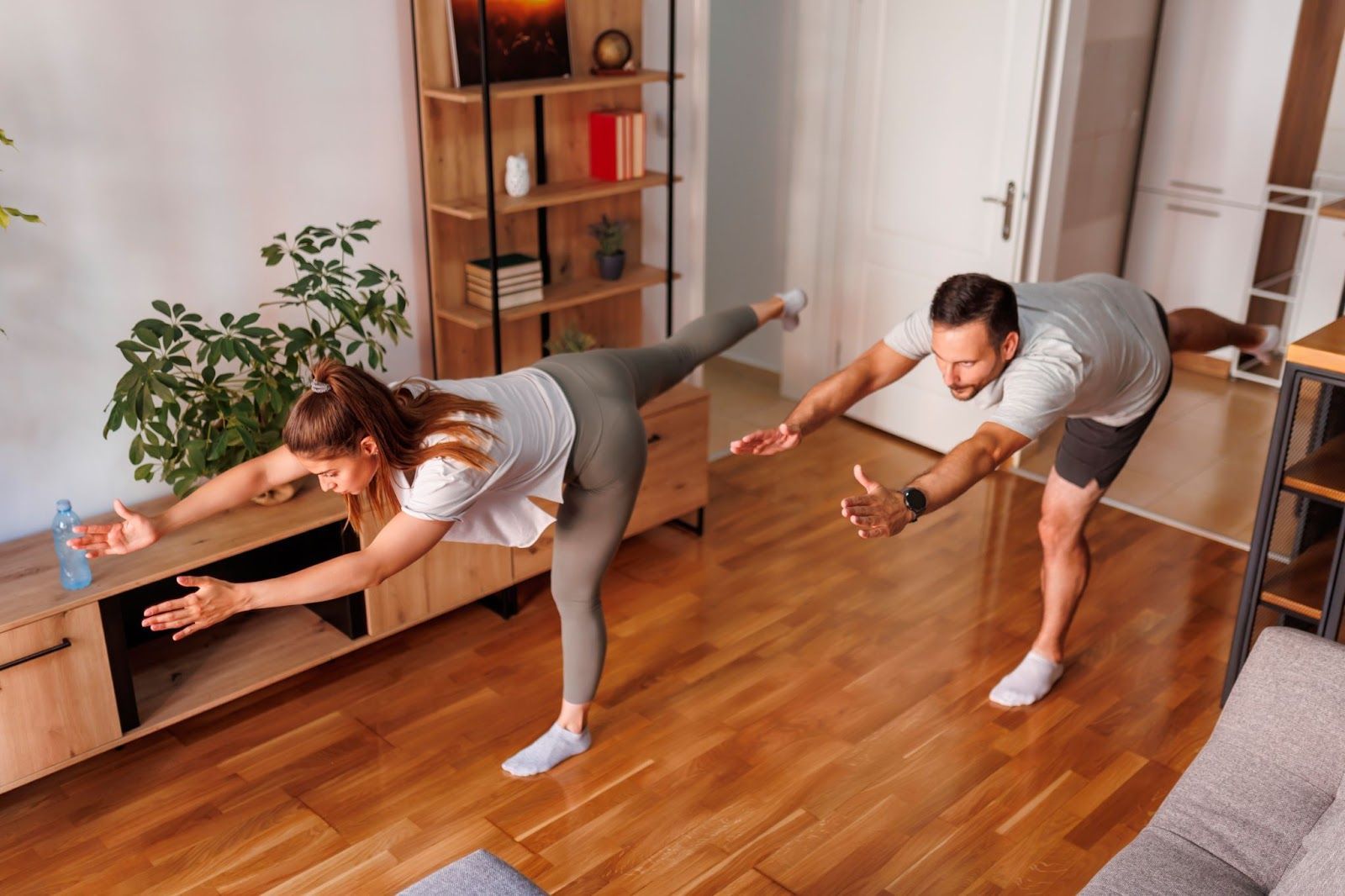 A young couple working out together and doing Yoga as morning exercise.
